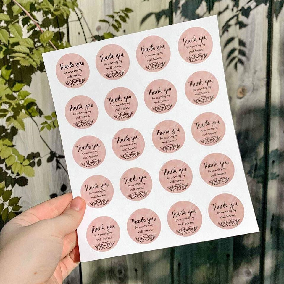 Sheet of round thank-you stickers held up outdoors โ thank-you sticker printing Dubai