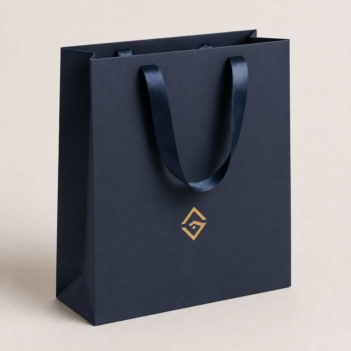 Navy boutique retail bag with gold logo and ribbon handles — ALEF UAE