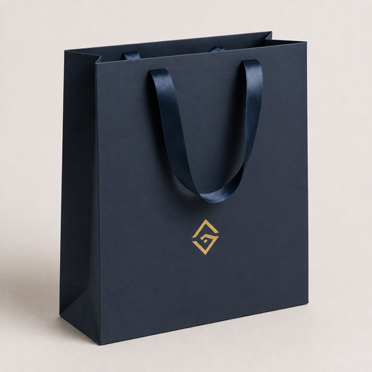 Navy boutique retail bag with gold logo and ribbon handles — ALEF UAE