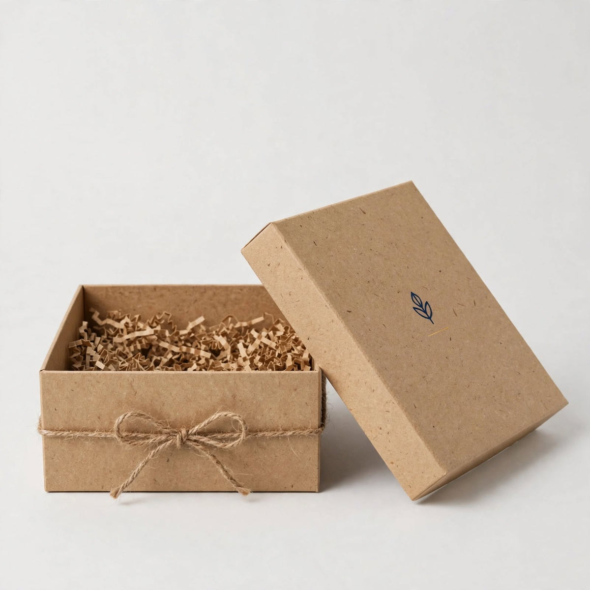 Natural kraft rigid gift box open with twine bow and shredded kraft filler — custom eco gift box Dubai