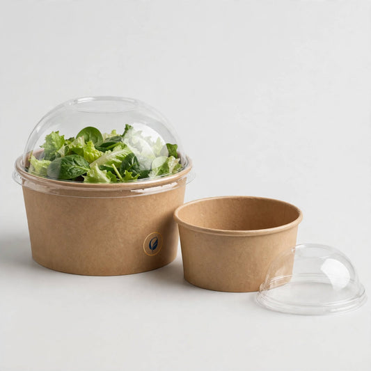 Kraft paper bowl with clear domed lid filled with salad, second empty bowl beside it — custom paper bowl packaging Dubai