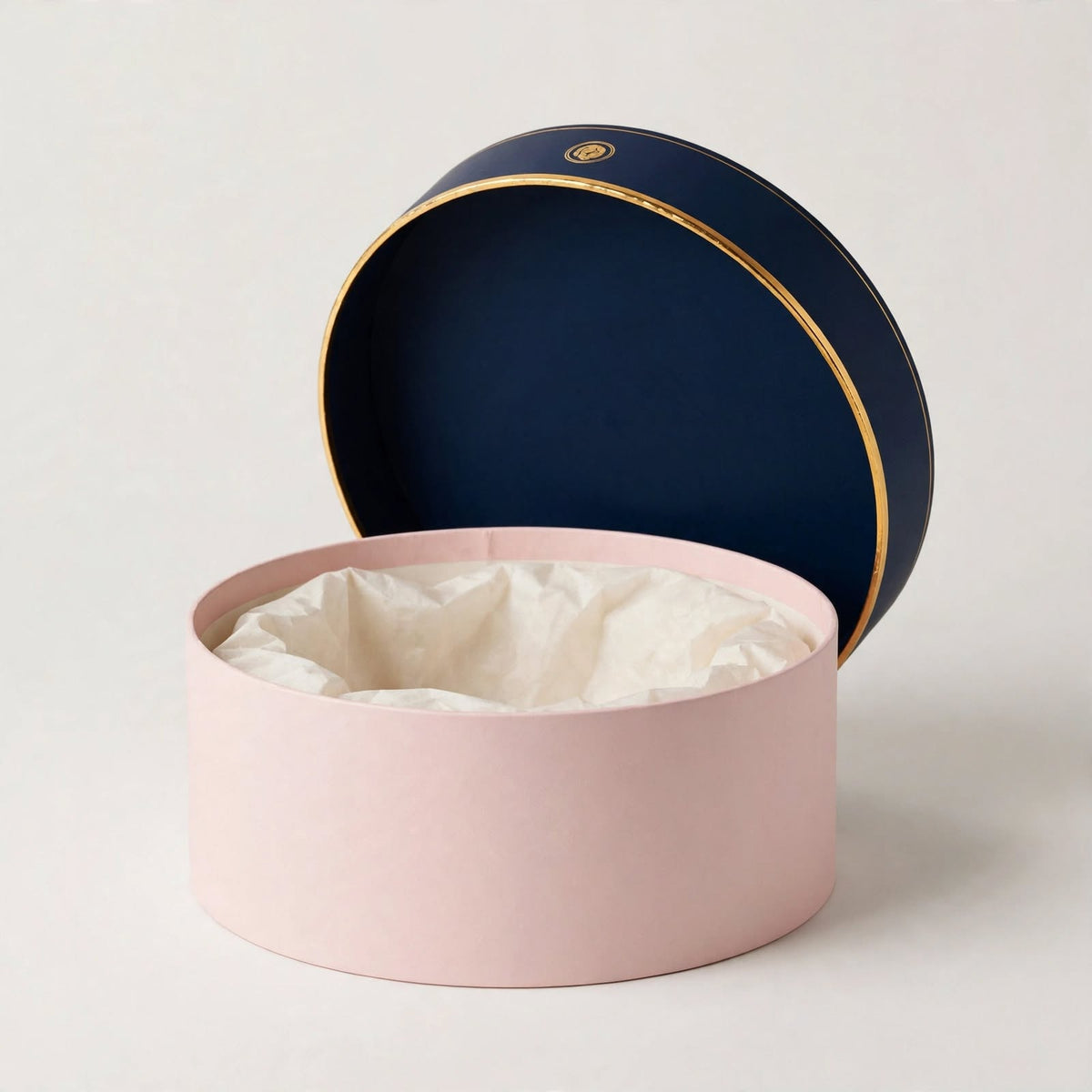 Round hat-box style gift box in blush with navy lid and tissue lining — custom round gift box Dubai