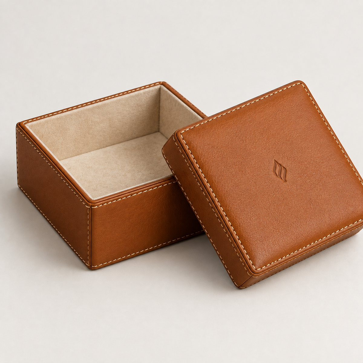 Cognac stitched leather gift box open with suede-lined interior — custom leather packaging Dubai