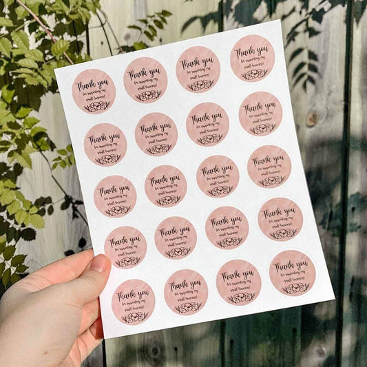 Sheet of round thank-you stickers held up outdoors — thank-you sticker printing Dubai